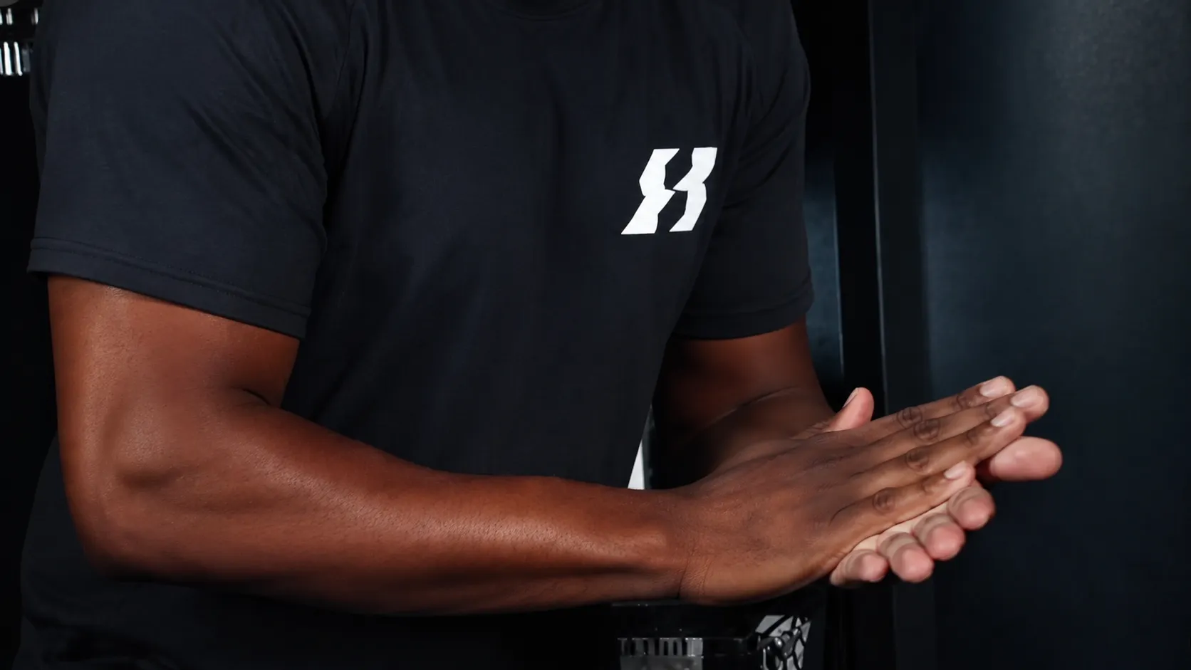Byron Laws in a Hands of Time Wellness t-shirt clapping his hands ready to begin a massage session